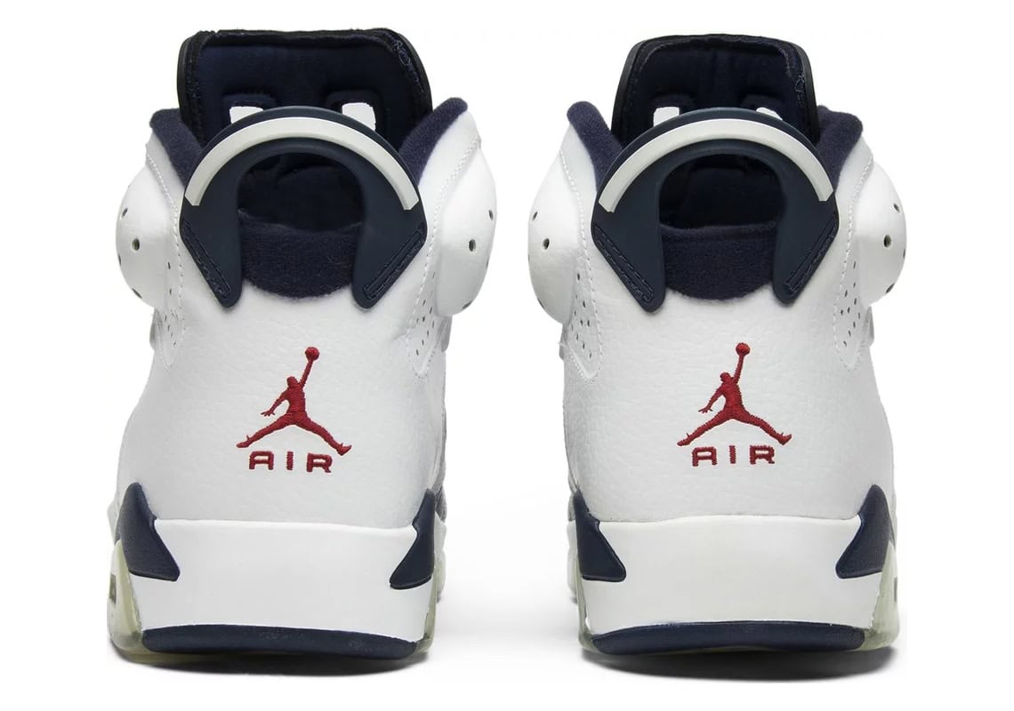 Classic Air Jordan 6 Retro shoes in white and navy colorway, featuring signature Jumpman logo.