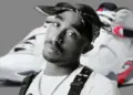 Black-and-white portrait of Tupac Shakur in a bandana, with a pair of retro sneakers blurred in the background